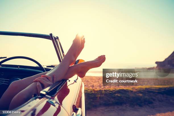 convertible car with womans feet hanging out - sydney beach stock pictures, royalty-free photos & images