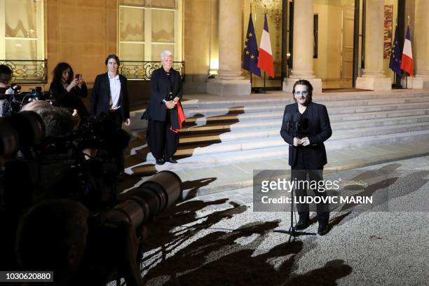 Irish lead singer of rock band U2, Paul David Hewson aka Bono delivers a statement in the courtyard of the Elysee Palace, in Paris, after a meeting...