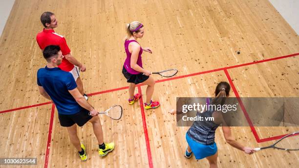 erhöhte ansicht von vier personen squash spielen - squash sport stock-fotos und bilder