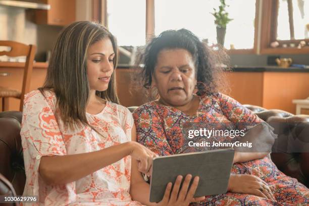 deux femmes autochtones, à l’aide de tablette numérique - australian culture stock photos et images de collection
