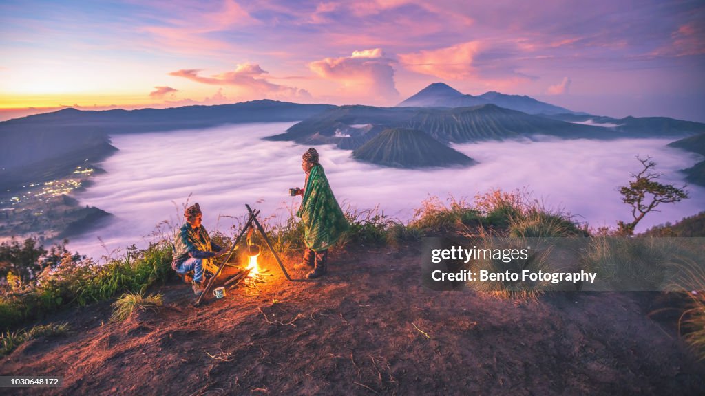 2 Local indonesian doing campfire while sunrise with Mt.bromo in background
