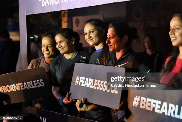 Women hold placards as they participate in The Fearless Run, a midnight run of 5 kilometers, which was organised in the presence of Delhi Police...