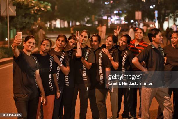Women take selfies before participating in The Fearless Run, a midnight run of 5 kilometers, which was organised in the presence of Delhi Police...