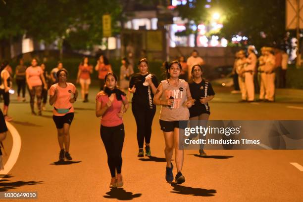 Women participate in The Fearless Run, a midnight run of 5 kilometers, which was organised in the presence of Delhi Police officials in the capital,...