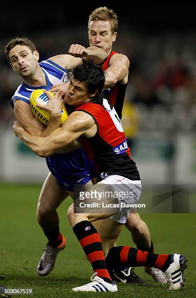 Angus Monfries of the Bombers tackles Brady Rawlings of the Kangaroos during the round 17 AFL match between the North Melbourne Kangaroos and the...