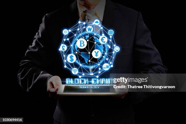 businessman hold the blockchain hologram on tablet, business and technology, internet of thinks and network the concept of cryptocurrency, blockchain "r"n"r"n - weltmarkt stock-fotos und bilder