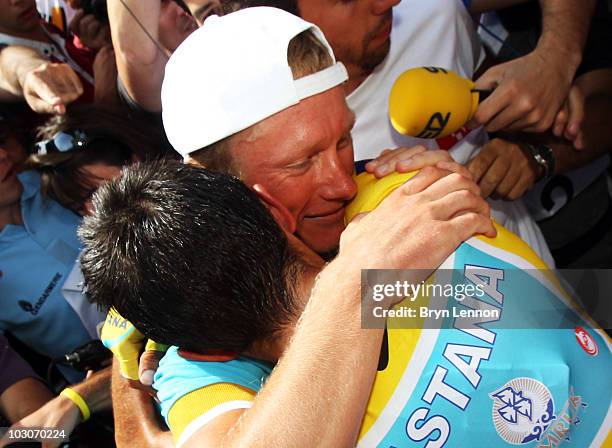 Team mate Alexandre Vinokourov of Kazachstan congratulates Alberto Contador of Spain and the Astana Team after stage nineteen, a 52km individual time...