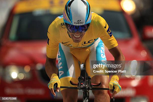 Race leader Alberto Contador of team Astana crosses the finish line in the yellow jersey following stage 19 of the Tour de France on July 24, 2010 in...