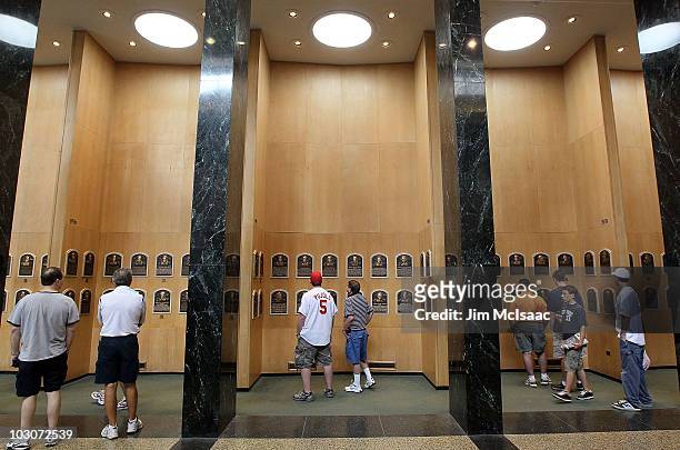 Patrons of the Baseball Hall of Fame and Museum view the plaques of inducted members during induction weekend on July 24, 2010 in Cooperstown, New...