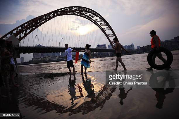 Residents play at the flooded river bank of Longwangmiao water area where the Hanjiang River merges into the Yangtze River on July 24, 2010 in Wuhan...