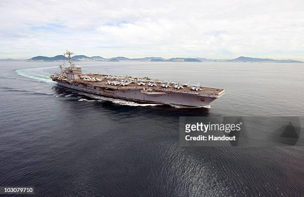 In this handout from the U.S. Navy the aircraft carrier USS George Washington departs on July 25, 2010 from Busan, South Korea. The United States and...
