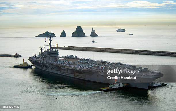 In this handout from the U.S. Navy the aircraft carrier USS George Washington departs on July 25, 2010 from Busan, South Korea. The United States and...