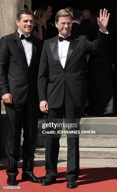 German Foreign Minister and vice-chancellor Guido Westerwelle and his partner Michael Mronz poses for photographers at the 'Festspielhaus' ahead of...