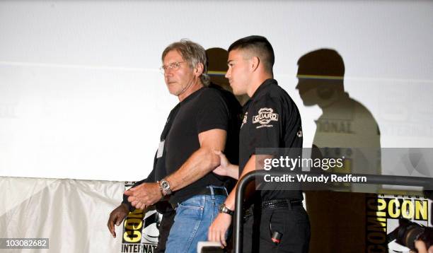 Harrison Ford is escorted by security after speaking at the Cowboys and Aliens panel at Comic-Con on July 24, 2010 in San Diego, California.