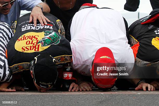 Jamie McMurray, driver of the Bass Pro Shops/Tracker Boats Chevrolet, celebrates by kissing the bricks with team co-owner Chip Ganassi after winning...