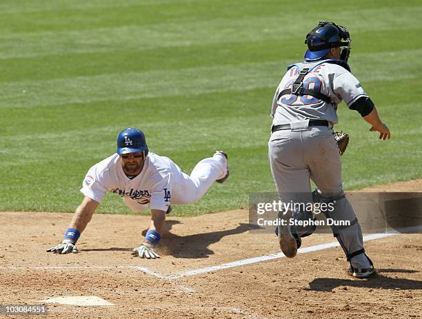 Casey Blake of the Los Angeles Dodgers slides into home to score the game's only run past catcher Josh Thole of the New York Mets in the eighth...