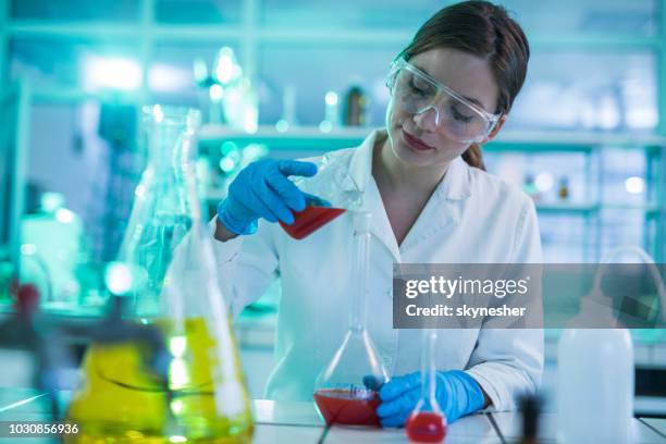 young female scientist mixing toxic substances in laboratory. - folding stock pictures, royalty-free photos & images