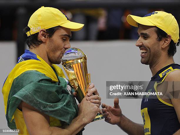 Brazilian captain Giba kisses the trophy next to teammate libero Mario during the awards ceremony after defeating Russia in their World League 2010...