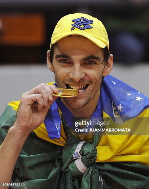 Brazil's captain Giba bites the gold medal during celebrations after the World League 2010 final against Russia at Orfeo Superdomo stadium in Cordoba...