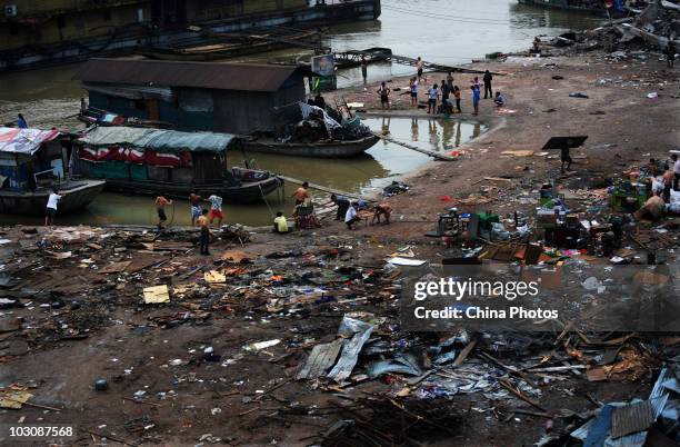 People remove belongings as parking lot and freight yard submerged by floods are being demolished, near water area where the Yangtze River and...