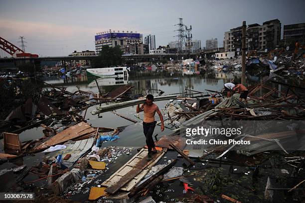 People gather belongings as parking lot and freight yard submerged by floods are being demolished, near water area where the Yangtze River and...