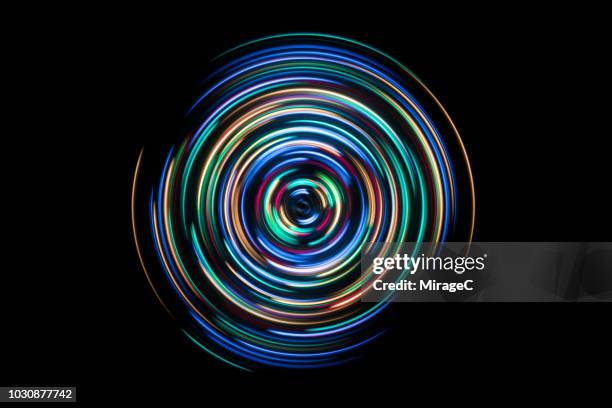 colorful spinning light trails - black background technology stockfoto's en -beelden