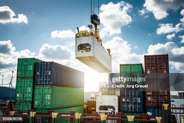 refrigerated container being loaded on a container ship - porto foto e immagini stock