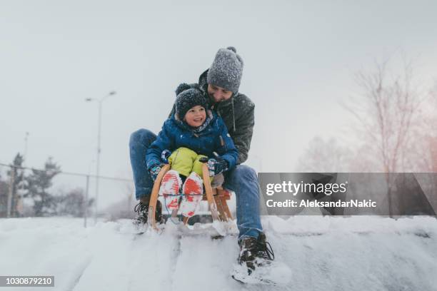 sledding with my dad - snow scene stock pictures, royalty-free photos & images