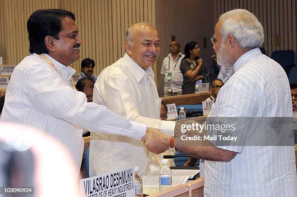 Gujarat Chief Minister Narendra Modi shakes hands with Power Minister Sushil Kumar Shinde and Vilasrao Deshmukh during the 55th meeting of National...