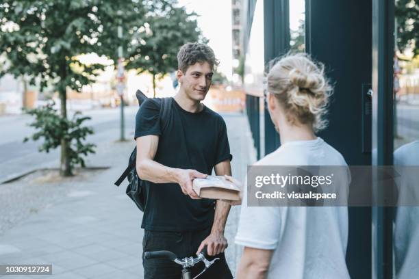 bike courier delivering a package to client - bike messenger stock pictures, royalty-free photos & images