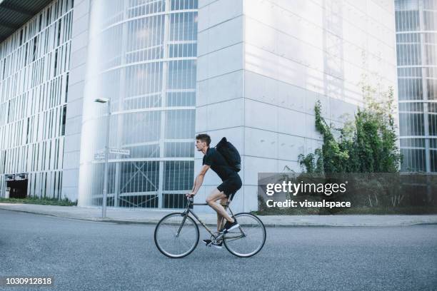 fahrradkurier fahren auf der straße. - fahrrad urban stock-fotos und bilder