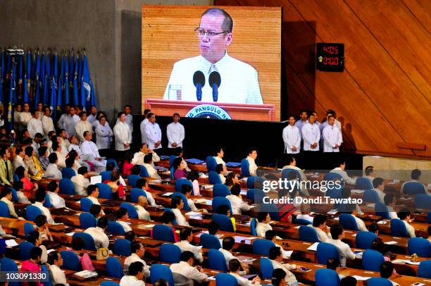 President Of The Philippines Benigno "NoyNoy" Aquino is shown on a screen as he delivers his first State Of The Nation Address following his...