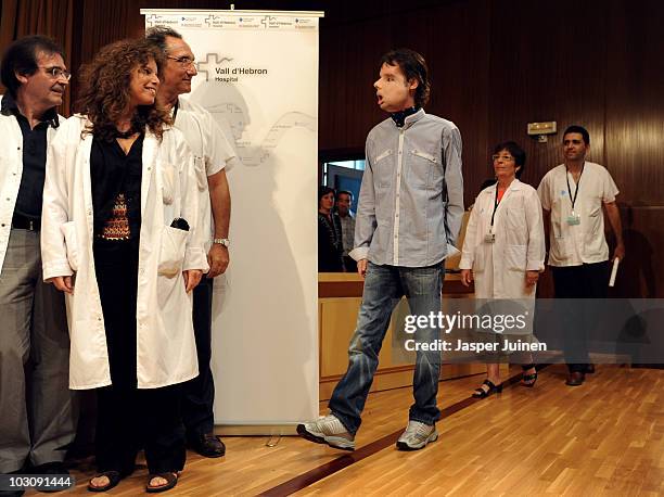 Oscar, the world's first full face transplant recipient, walks past medical staff before participating in a press conference to chart his progress...