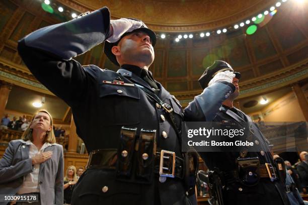 Braintree Police officers Donald Delaney, center and William Cushing Jr., right, salute during the national anthem during the 35th Annual Trooper...