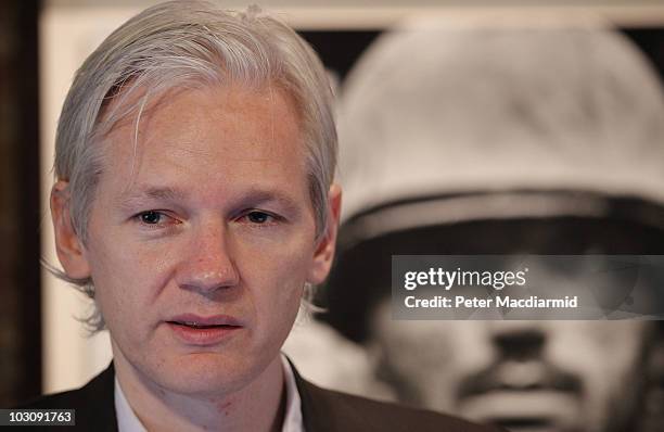 Julian Assange of the WikiLeaks website speaks to reporters in front of a Don McCullin Vietnam war photograph at The Front Line Club on July 26, 2010...