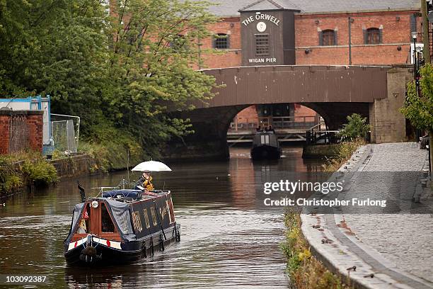 Narrow boat cruises through the rain at Wigan Pier as it makes it's way along the Liverpool and Leeds canal on July 26, 2010 in Wigan, England. A...