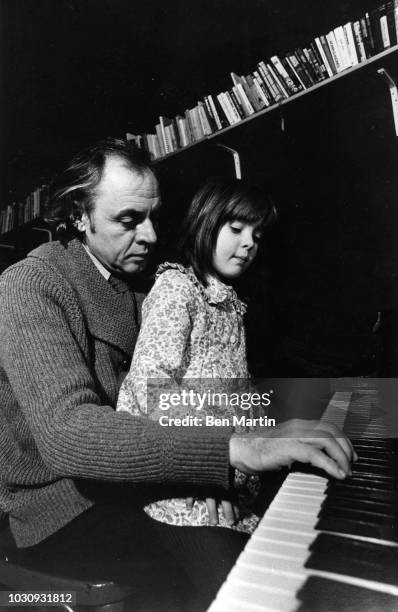 Ronald David Laing Scottish psychiatrist playing piano with daughter Natasha in the parlor of their basement flat in Hampstead, March 4th 1976.