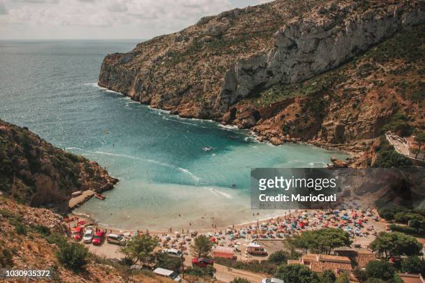 crowded small beach - javea stock pictures, royalty-free photos & images