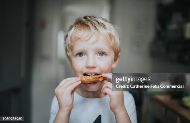 kid eating a bagel - nut butter stock pictures, royalty-free photos & images