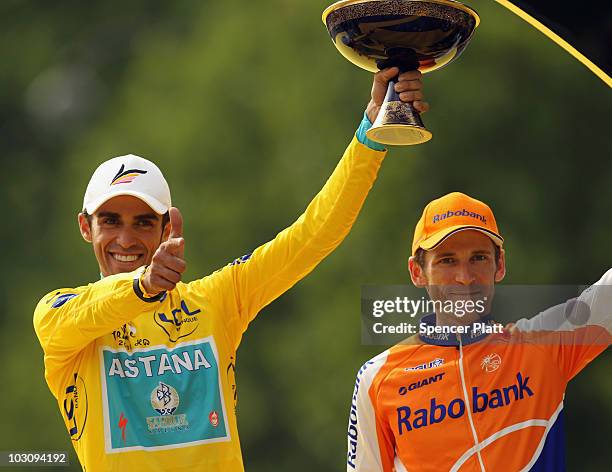 Alberto Contador of team Astana celebrates as Denis Menchov of team Rabobank looks on after the twentieth and final stage of Le Tour de France 2010,...