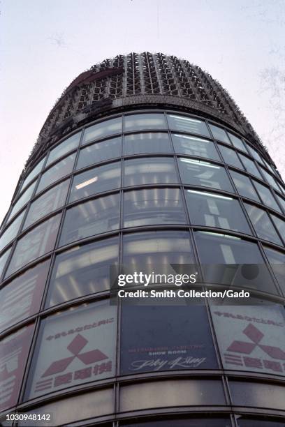 Low-angle view of building with logo for Japanese conglomerate Mitsubishi and sign in English reading Mitsubishi Electric Show Room, Sky King, in...