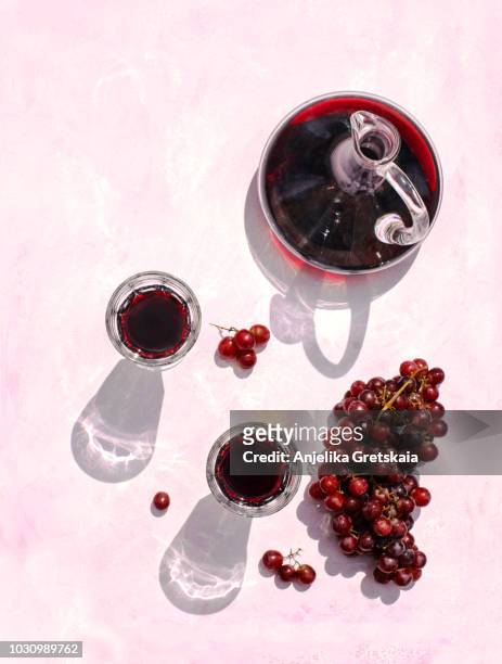 glasses of red wine, decanter and grape on pink background, top view - wine grapes stock pictures, royalty-free photos & images