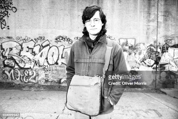 American born John Patrick Shanley, playwright, director, and screenwriter, stands against a graffitied wall in Riverside Park, early 1980s, New...
