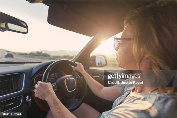woman driving suv at sunrise - right hand drive stock pictures, royalty-free photos & images