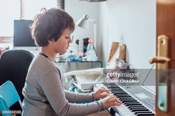 boy playing the piano (nine years old) in a domestic room - 8 9 years stock pictures, royalty-free photos & images