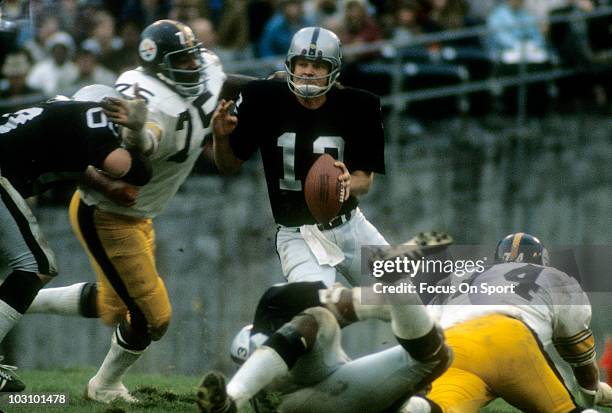 Defensive lineman Joe Greene of the Pittsburgh Steelers pursues quarterback Ken Stabler of the Oakland Raiders circa 1973 during an NFL football game...