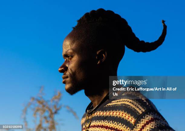 Himba tribe man with a special hairstyle which shows he is single, Cunene Province, Oncocua, Angola on July 13, 2018 in Oncocua, Angola.