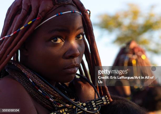 Himba tribe woman with a ray of light on her face, Cunene Province, Oncocua, Angola on July 13, 2018 in Oncocua, Angola.
