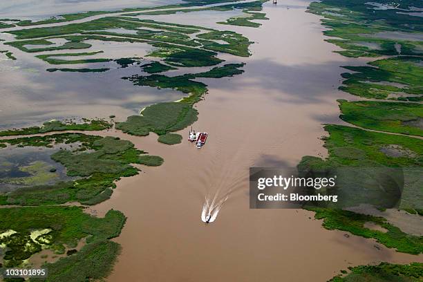 Vessels travel in a canal off the coast of Louisiana, U.S., on Monday, July 26, 2010. BP Plc returned to work on permanently plugging the source of...