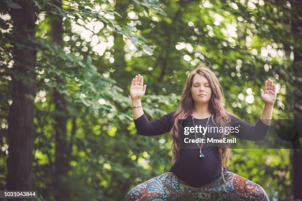 young mother to be practicing prenatal yoga outdoors - new age stock pictures, royalty-free photos & images